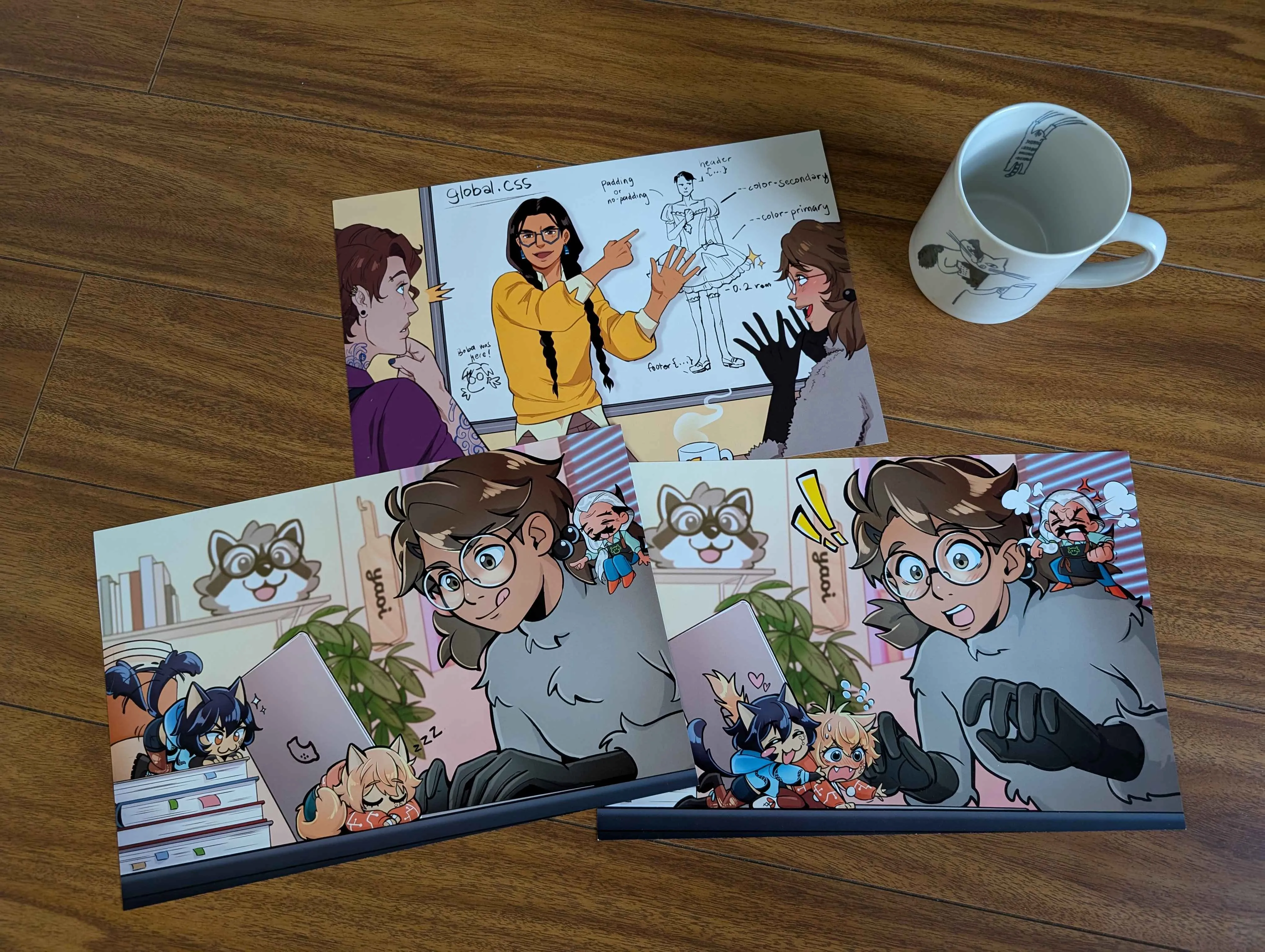 Three eight inch by twelve inch prints featuring characters from the Fujoshi
Guide to Web Development. A coffee mug in the corner gives a sense of the
prints’ size.